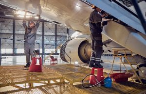 engineer working on aircraft wing in aircraft maintenance factory