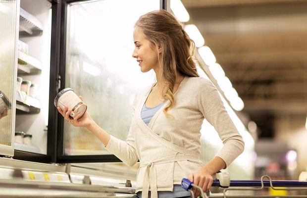 woman with ice cream at grocery store freezer
