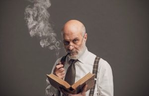 senior academic professor reading and smoking a pipe