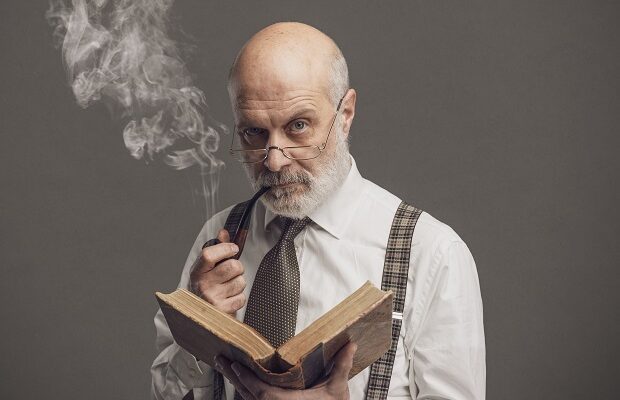 senior academic professor reading and smoking a pipe