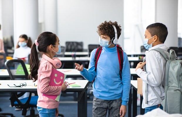 international pupils wearing medical masks and talking