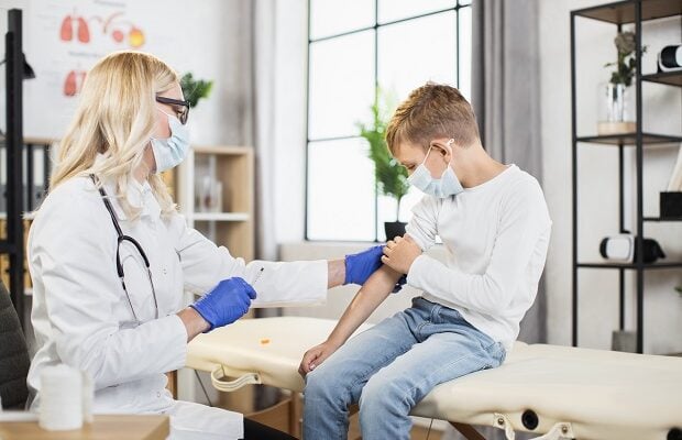 caucasian boy getting vaccine by female doctor at hospital