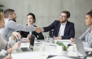 boss shaking hands with employee at meeting
