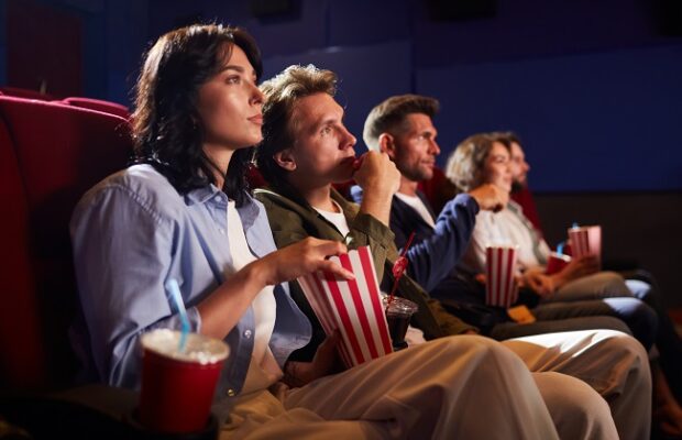 young people watching movie in cinema