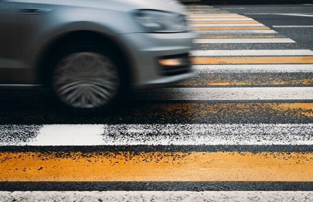 car driving into a pedestrian crossing. motion blur, selective focus. violation of traffic rules, road accident concept
