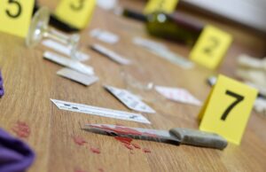 crime scene investigation numbering of evidences after the murder in the apartment. broken glass of wine, knife and bottle as evidence