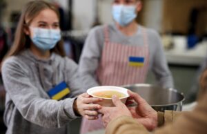 volunteers serving hot soup for ukrainian migrants in refugee centre, russian conflict concept.