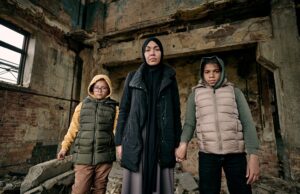young muslim woman holding her two daughters by hands