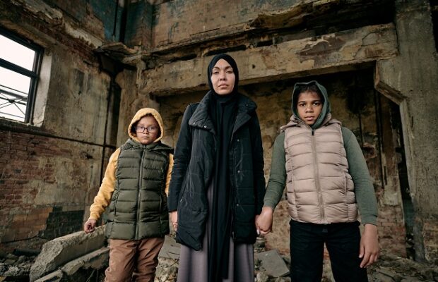 young muslim woman holding her two daughters by hands