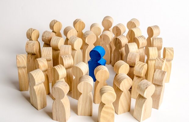 the blue figure of the leader is surrounded by a crowd of people. leadership and team management, an example for imitation. loyalty and trust. idol. like minded people and followers