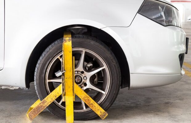 car wheel clamped for illegal parking violation at car park