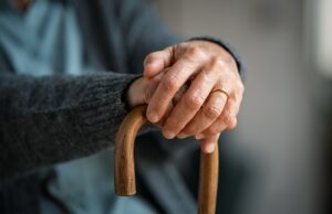 old woman hands holding walking stick