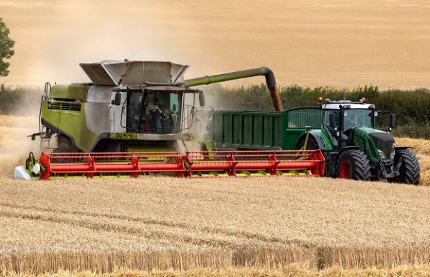 combine harvester working in a field of wheat england