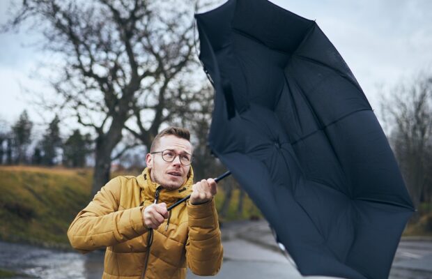 man with umbrella in wind and rain