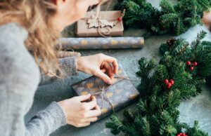 a woman is packing a christmas present. decorating gifts.