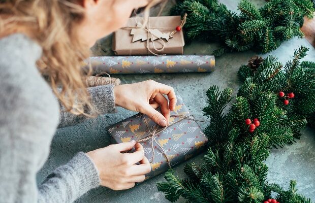 a woman is packing a christmas present. decorating gifts.
