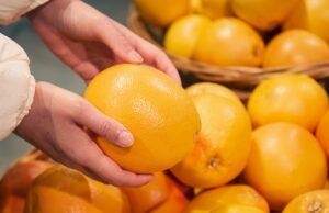 grapefruit in female hands, buying fruits in a supermarket.