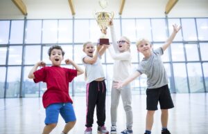 happy pupils holding trophy in gym