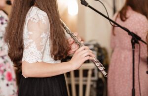 flutist, young girl playing the flute, hands, fingers on keys closeup, children playing transverse side blow flute, detail shot, classical music, wind instrument performance player up close abstract