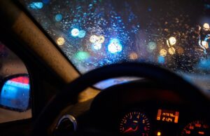 look on wet city through windshield from inside the car at rain weather at night
