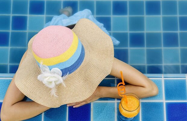woman relaxing at swimming pool, summer vacation