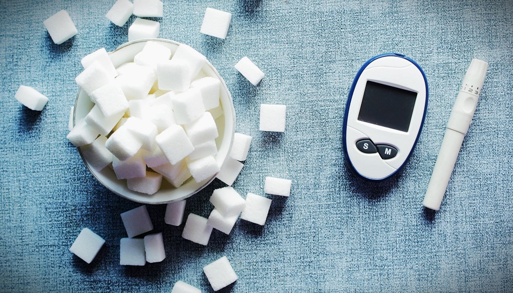 diabetic measurement tools and and white sugar cube on table