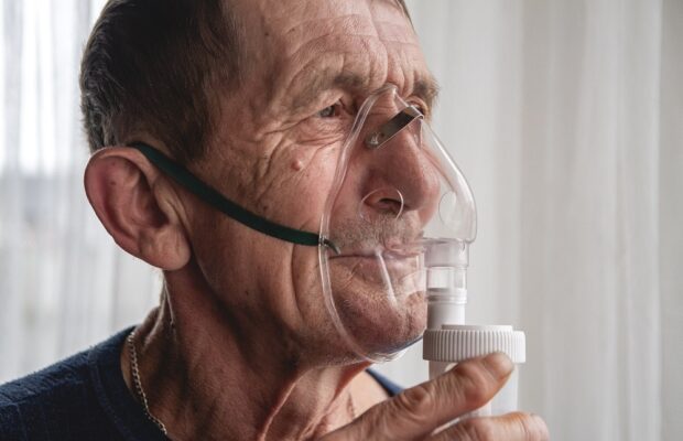 elderly senior with an oxygen mask in quarantine