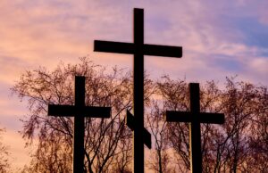 three crosses in silhouette at sunset, dramatic sky