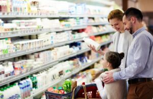 O familie face cumpărături la raionul de lactate din supermarket