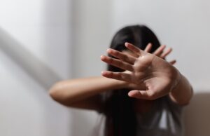 O fată ține mâinile la față încercând să oprească un act de violență