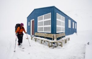 wapta traverse,canada,a skier leaving a refuge hut in mist and cloud conditions on the wapta traverse, a mountain hut to hut ski tour in alberta, canada.