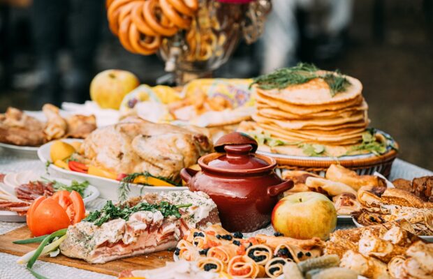 dishes of the traditional belarusian cuisine pancakes, pancakes with caviar, lard, bacon, baked chicken, honey and samovar with steering wheels. attribute of traditional folk celebration of maslenitsa