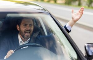 close up photo of an angry young businessman driving a car, shouting and waving his hands