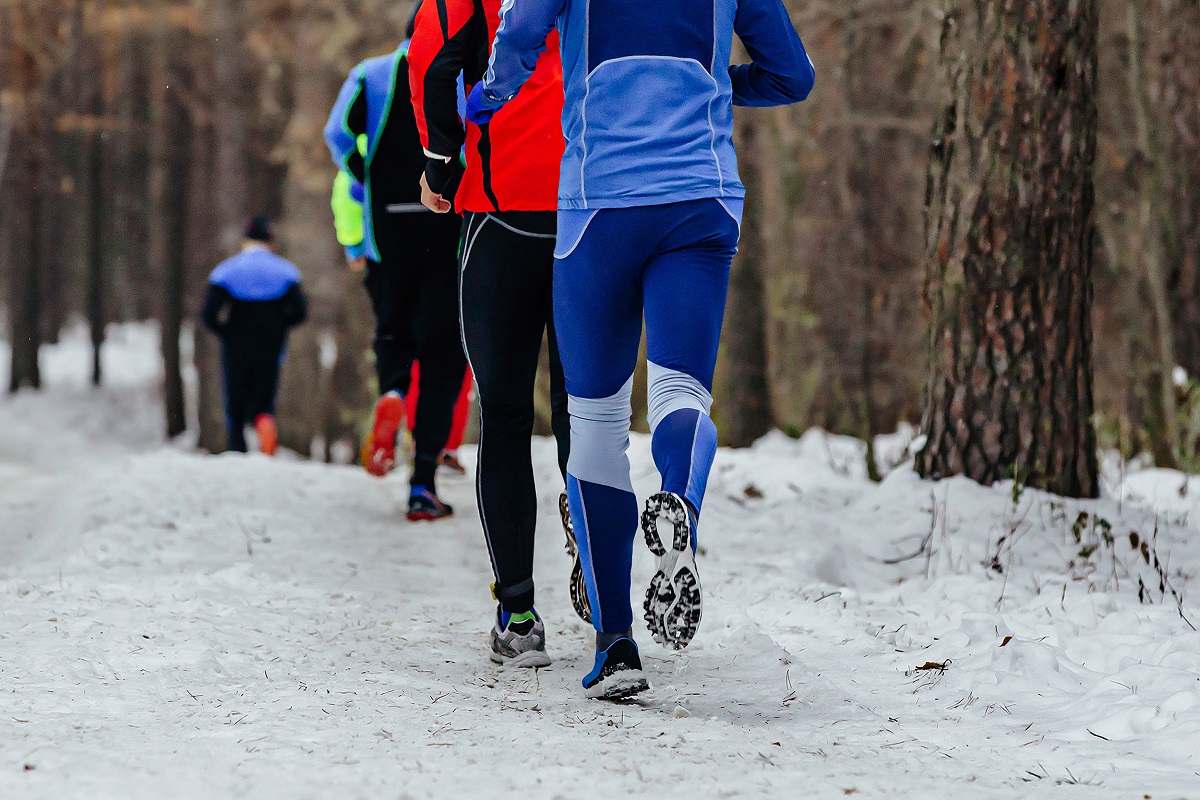 back group runners athletes running winter trail marathon, people jogging together snowy forest